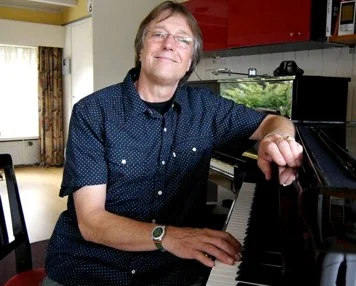 Jac van Lindt achter de vleugel in zijn lesstudio in Roermond